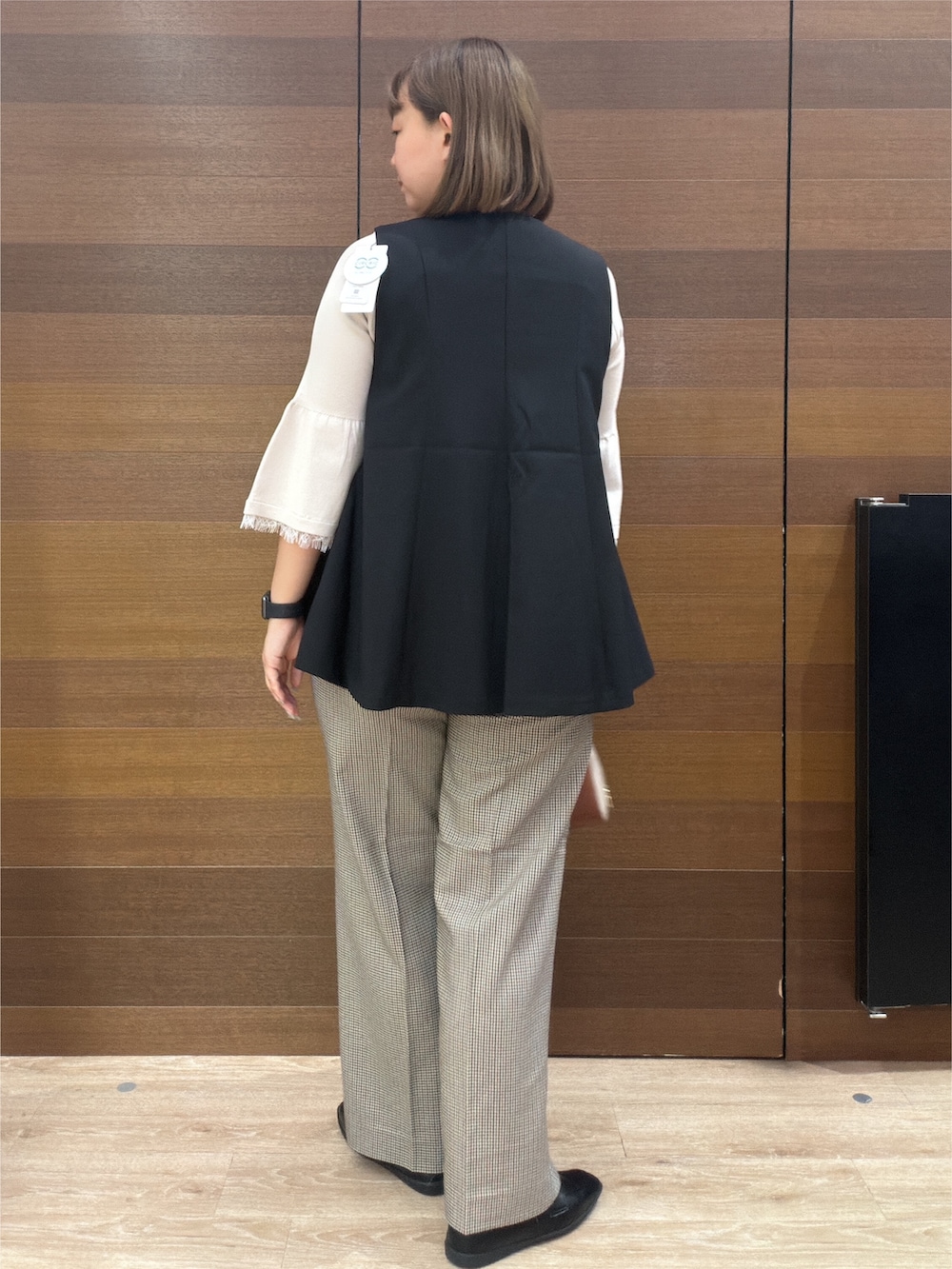 ブラック系のベスト、ベージュ系のニット/セーター、ブラウン系のその他パンツを着用したレディースの秋コーディネートの7枚目の写真