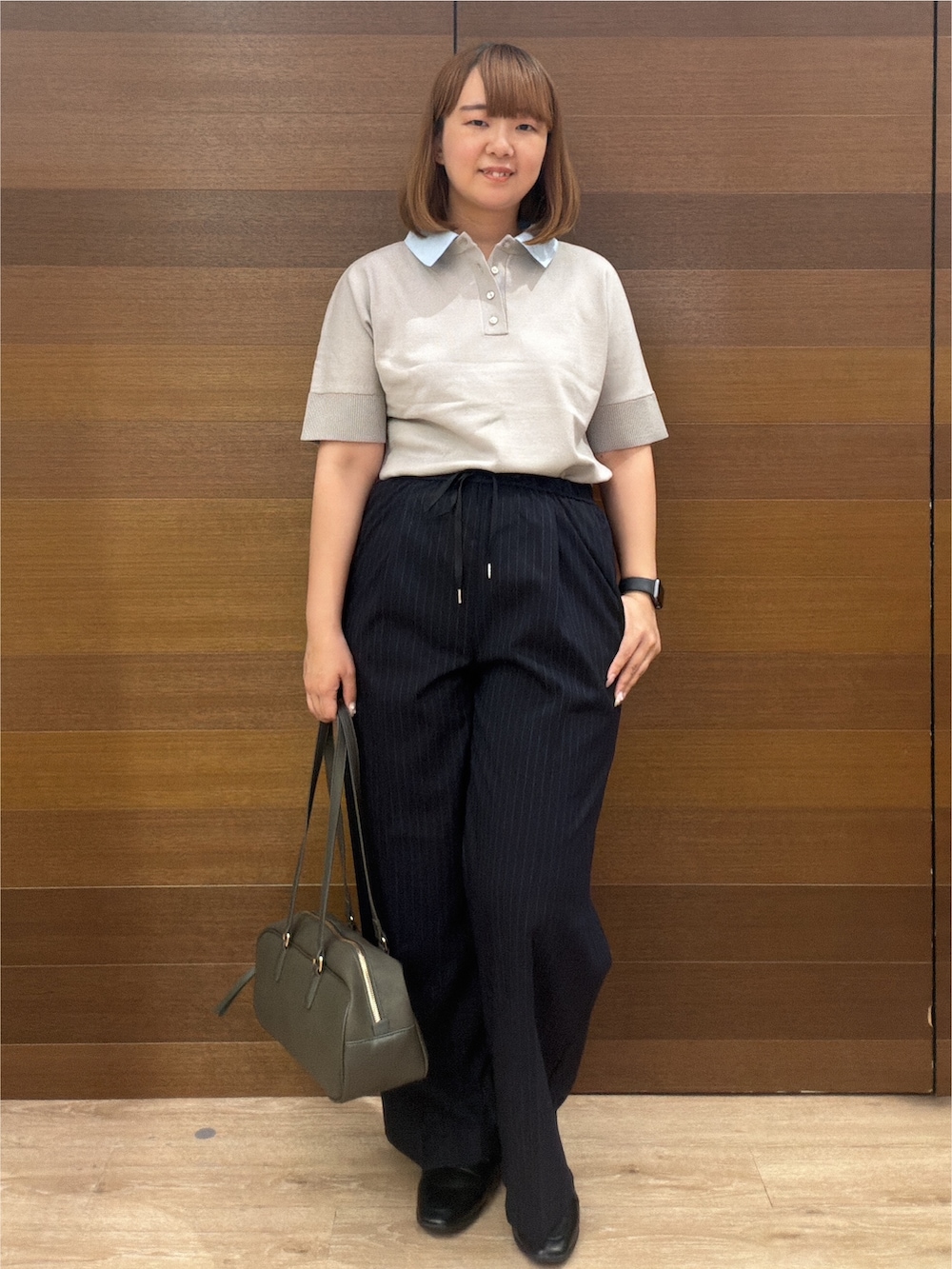グレー系のニット/セーター、ブルー系のその他パンツ、グリーン系のボストンバッグを着用したレディースの秋コーディネートの2枚目の写真