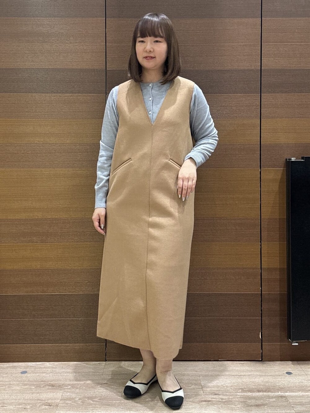グレー系のカーディガン/ボレロ、イエロー系のワンピース、ベージュ系のトートバッグを着用したレディースの冬コーディネートの3枚目の写真