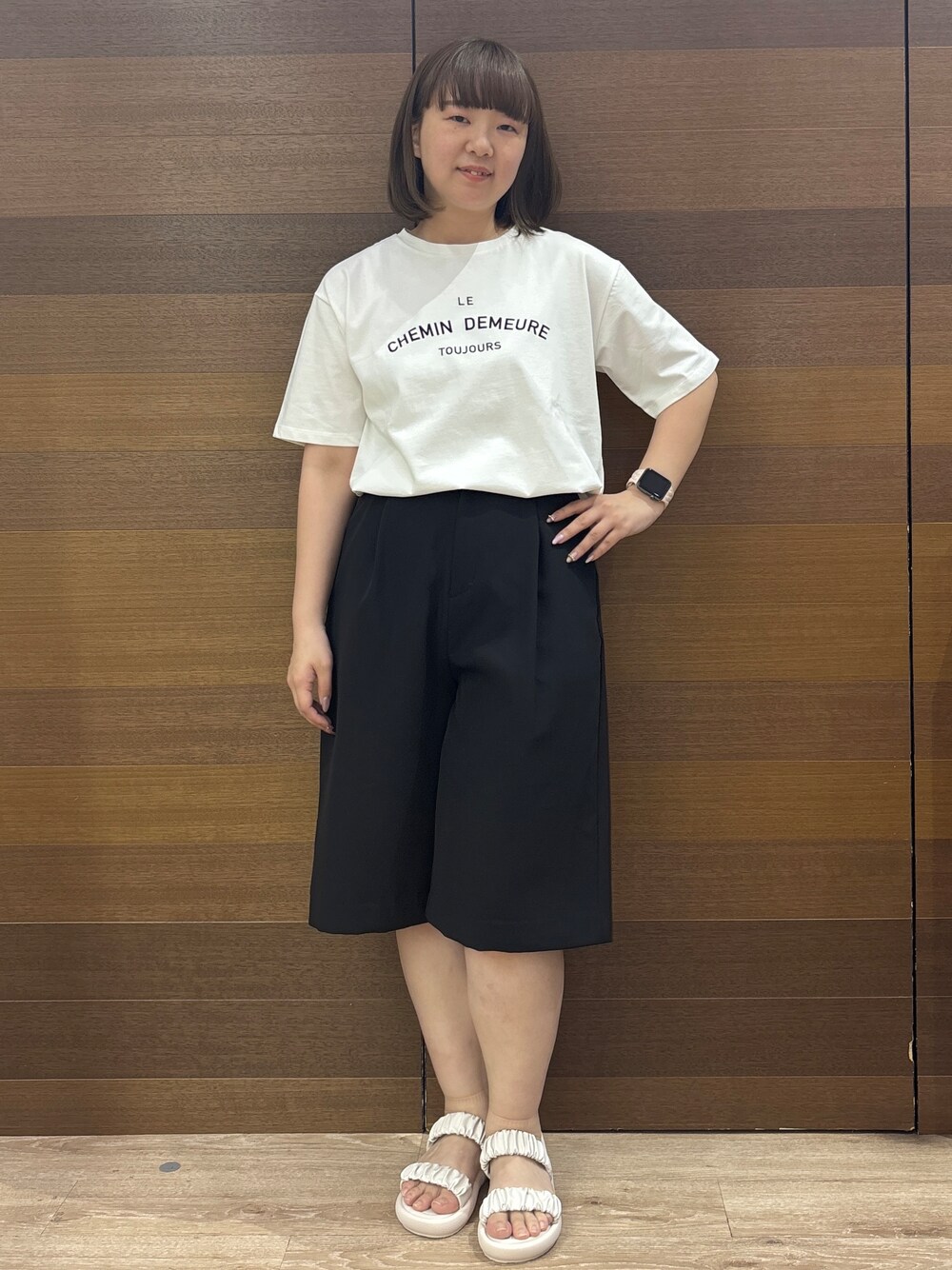 ホワイト系のトートバッグ、ホワイト系のサンダル、ブラック系のその他パンツを着用したレディースの春コーディネートの2枚目の写真