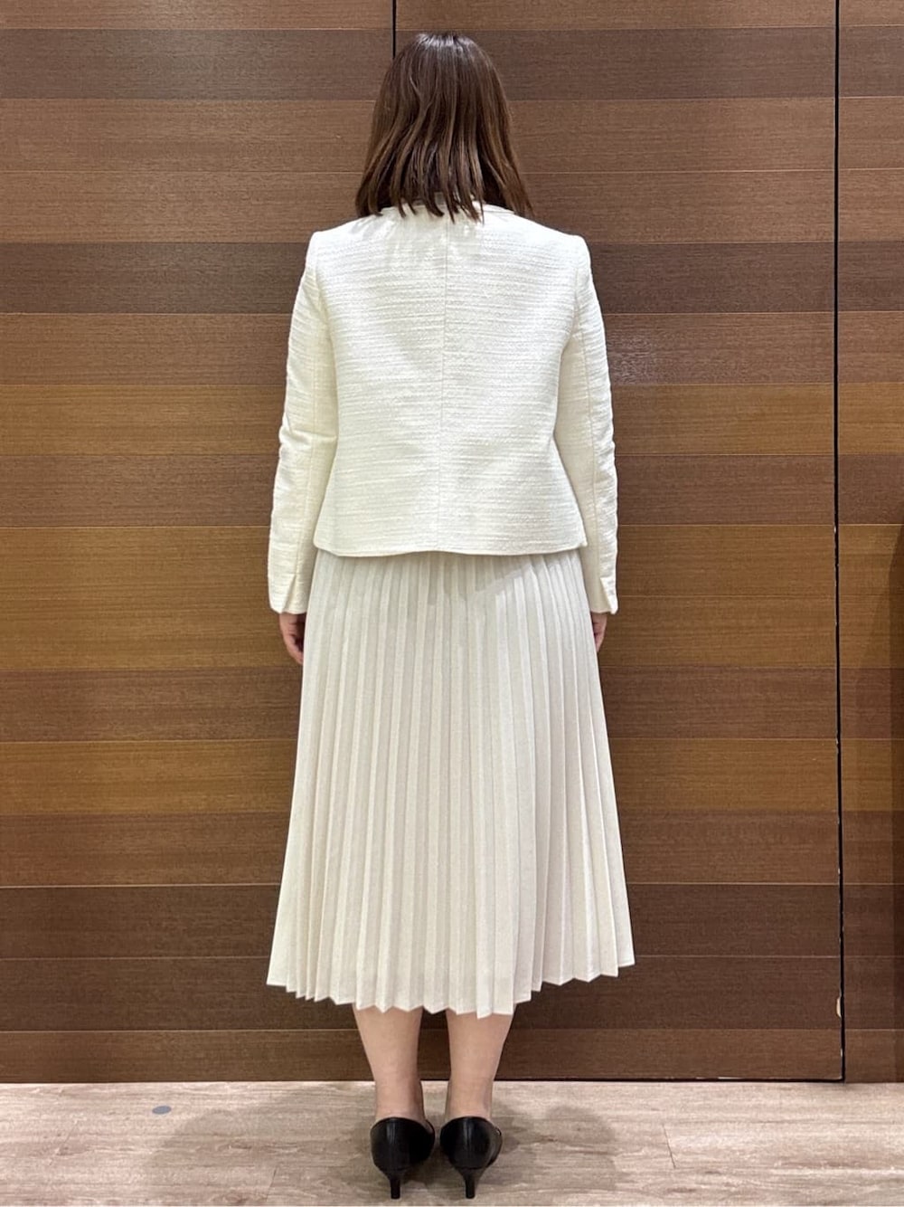 ホワイト系のノーカラージャケット、ベージュ系のシャツ/ブラウス、ベージュ系のスカートを着用したレディースの冬コーディネートの5枚目の写真