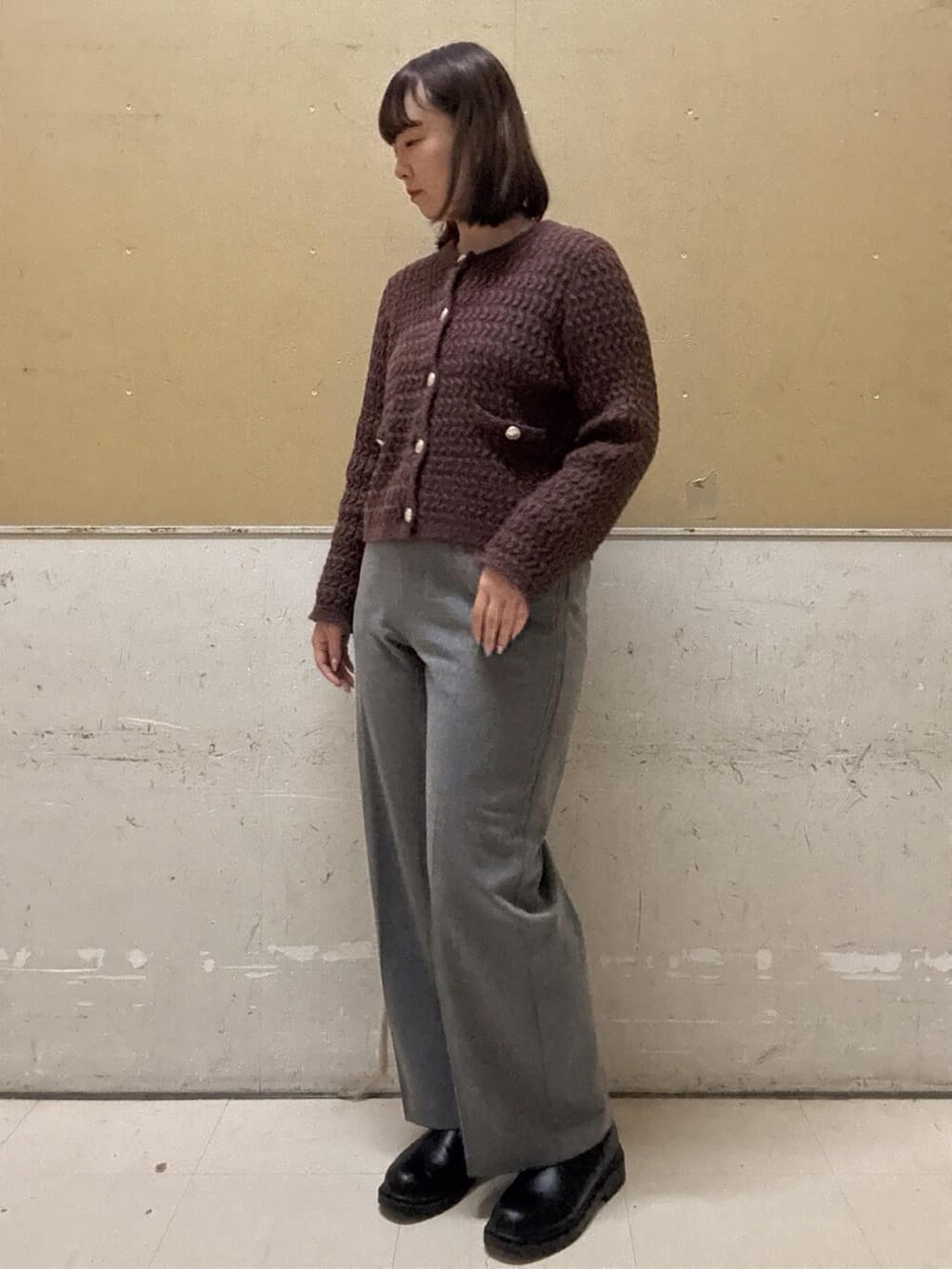 ブラウン系のカーディガン/ボレロ、グレー系のその他パンツ、ブラック系のトートバッグを着用したレディースの冬コーディネートの5枚目の写真