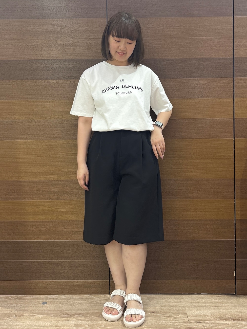 ホワイト系のトートバッグ、ホワイト系のサンダル、ブラック系のその他パンツを着用したレディースの春コーディネートの3枚目の写真
