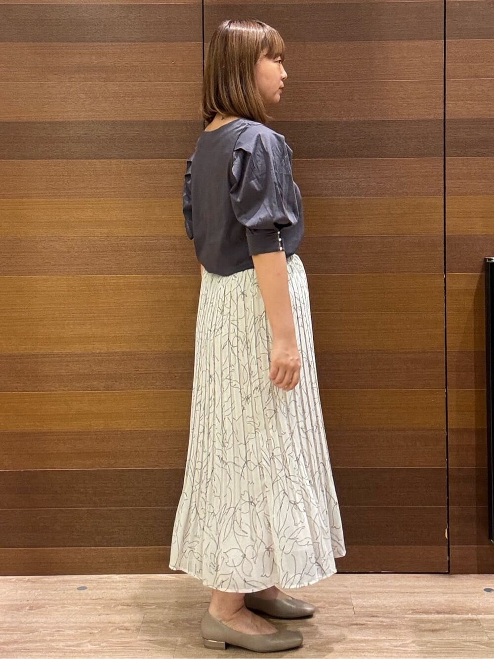 グレー系のTシャツ/カットソー、ブラック系のトートバッグ、ベージュ系のパンプスを着用したレディースの夏コーディネートの5枚目の写真