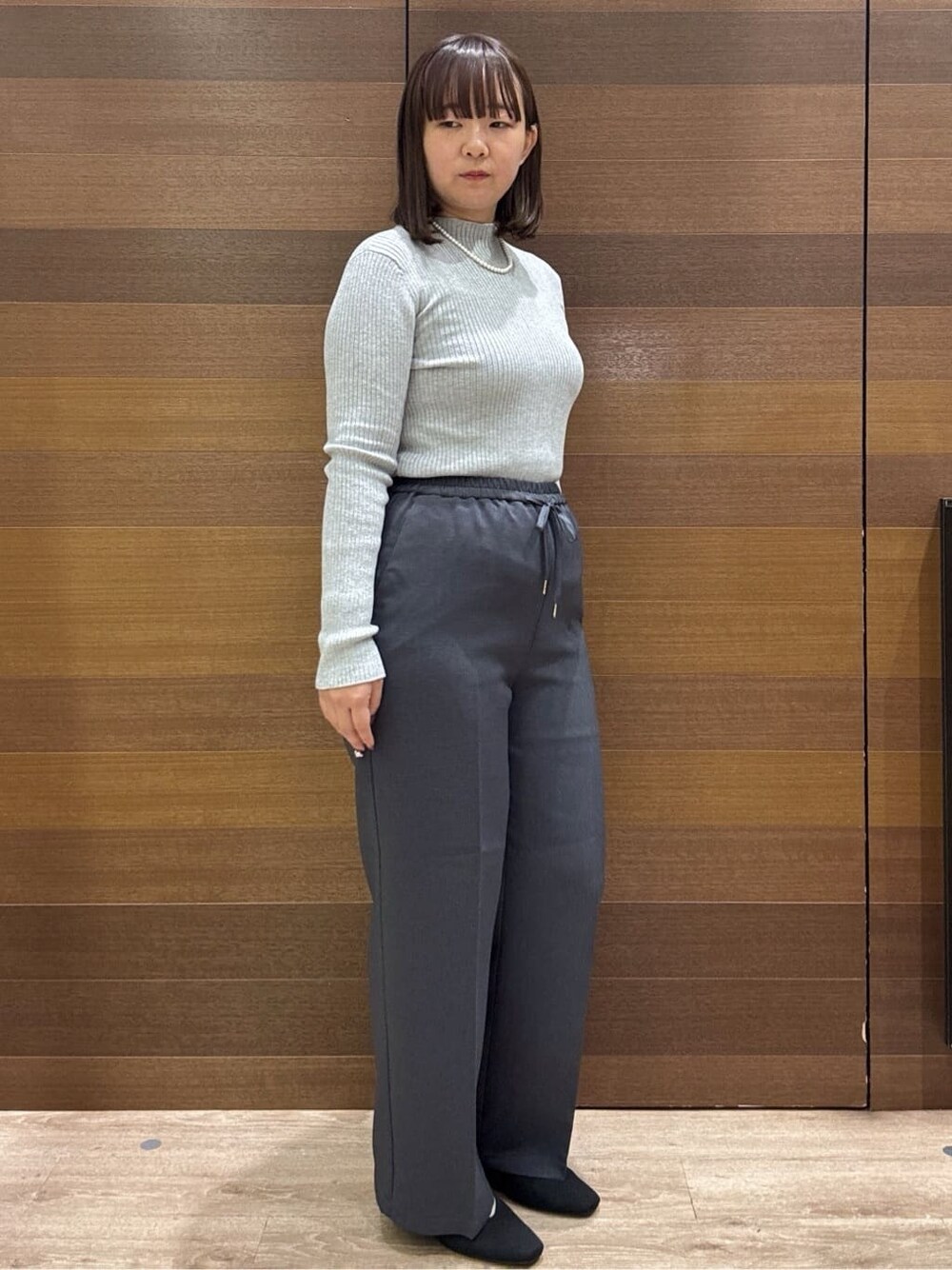 グレー系のニット/セーター、グレー系のその他パンツ、ブラック系のボストンバッグを着用したレディースの冬コーディネートの6枚目の写真