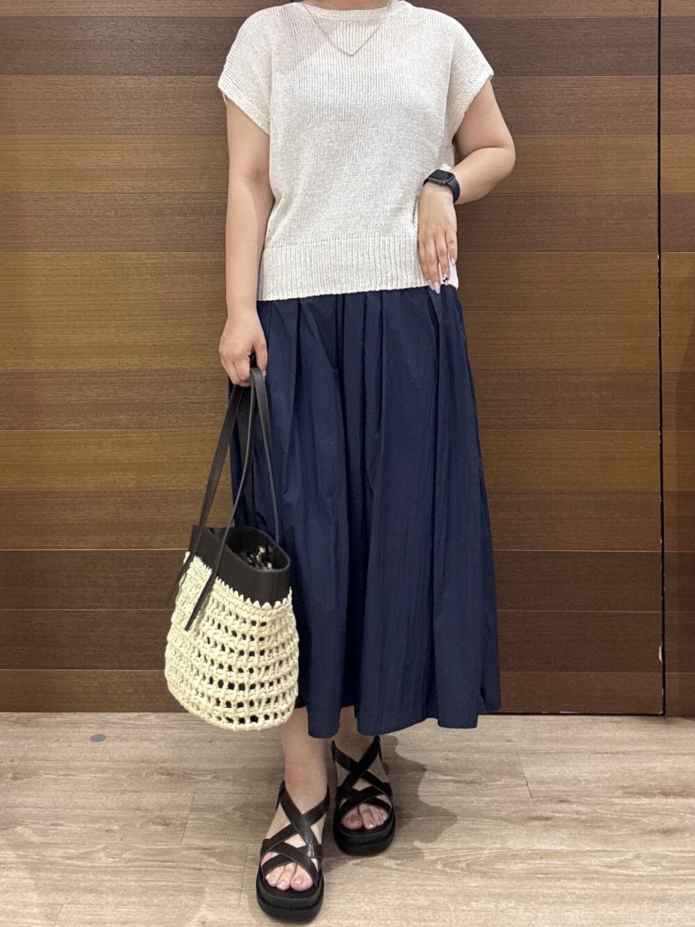 ホワイト系のニット/セーター、ブルー系のスカート、ブラック系のトートバッグを着用したレディースの夏コーディネートの8枚目の写真