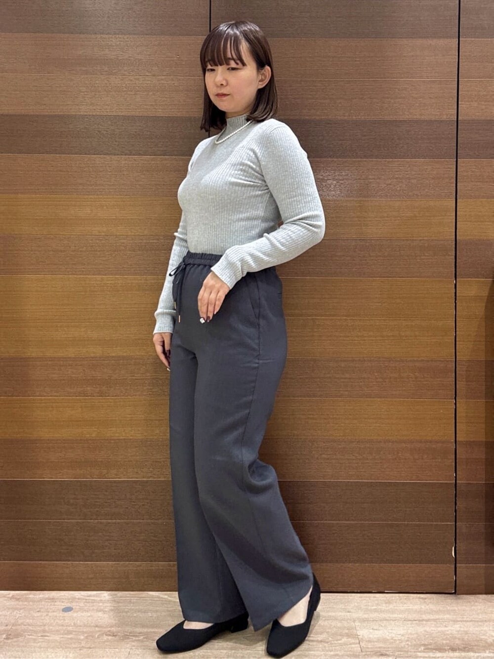 グレー系のニット/セーター、グレー系のその他パンツ、ブラック系のボストンバッグを着用したレディースの冬コーディネートの5枚目の写真