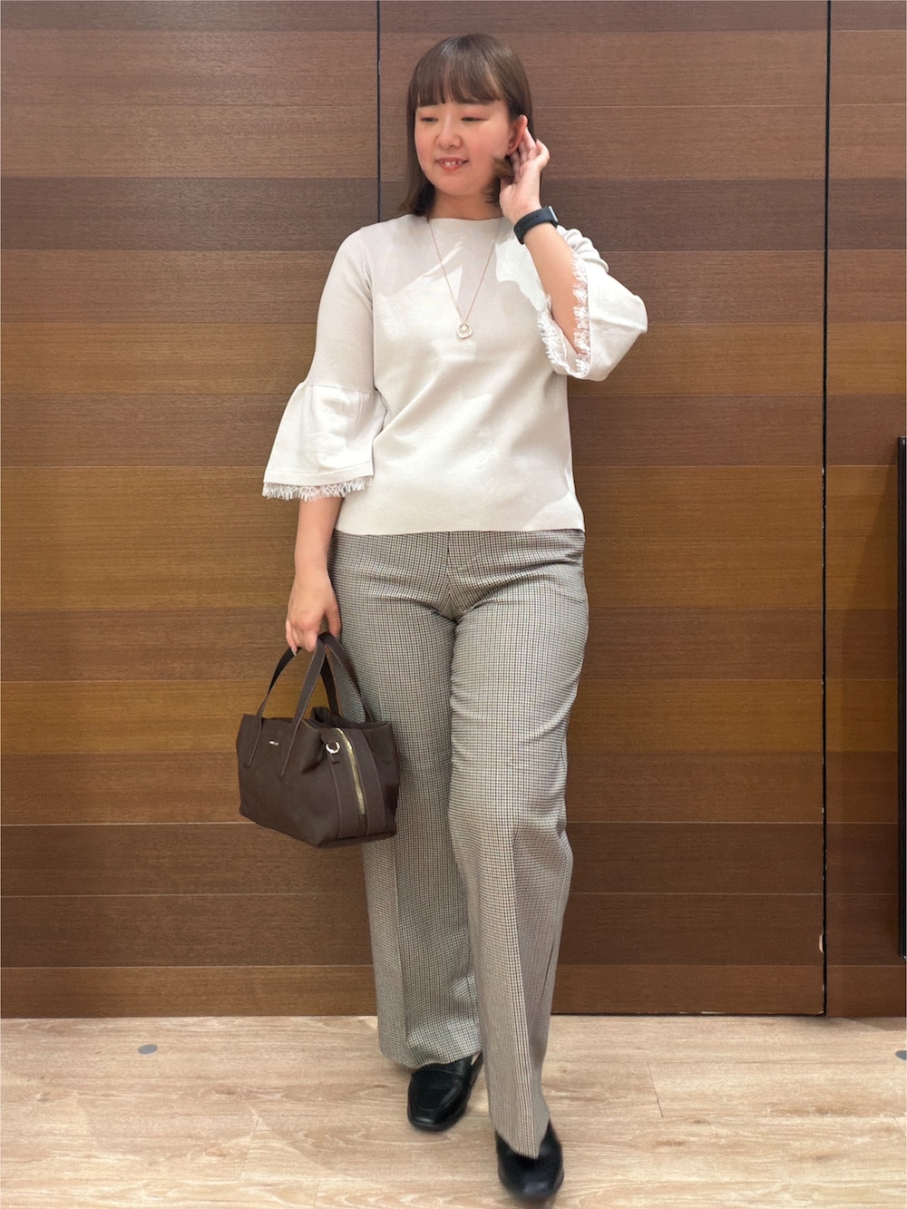 ベージュ系のニット/セーター、ブラウン系のその他パンツ、ブラウン系のボストンバッグを着用したレディースの秋コーディネートの2枚目の写真