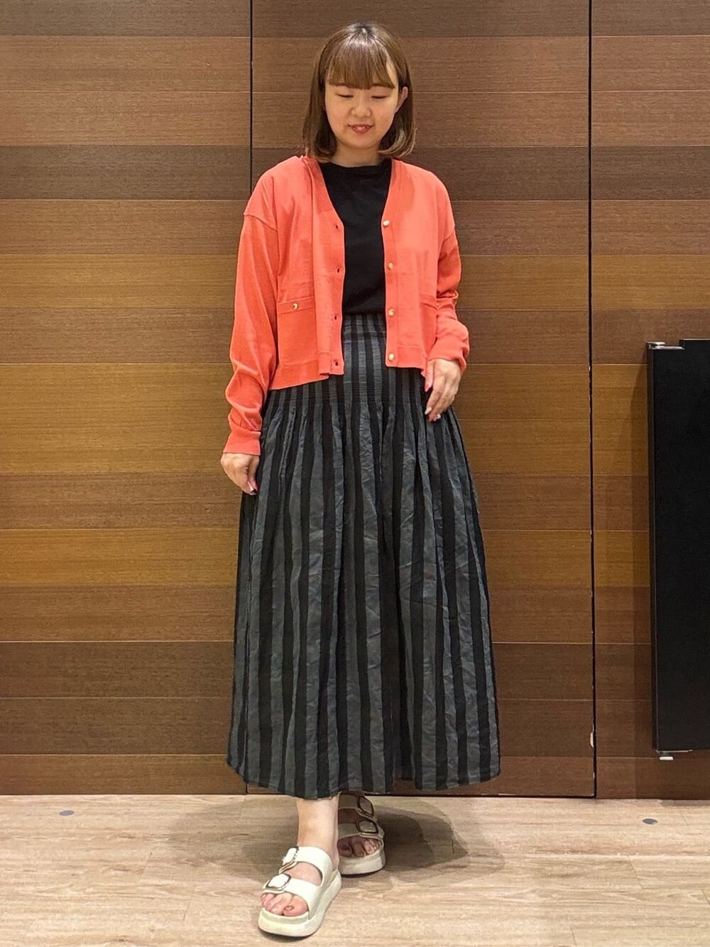 ブラック系のTシャツ/カットソー、ベージュ系のスカート、ベージュ系のショルダーバッグを着用したレディースの夏コーディネートの2枚目の写真