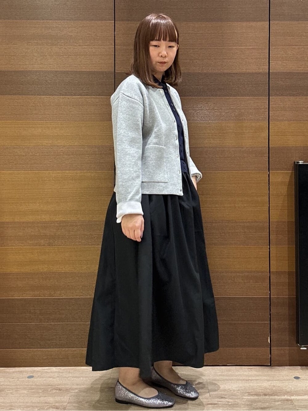 グレー系のカーディガン/ボレロ、ブルー系のワンピース、ブラック系のショルダーバッグを着用したレディースの冬コーディネートの6枚目の写真