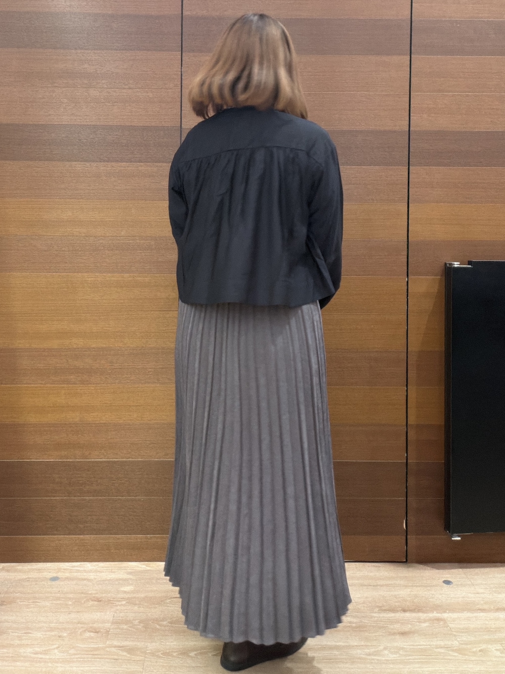 ブラック系のカーディガン/ボレロ、レッド系のニット/セーター、グレー系のスカートを着用したレディースの秋コーディネートの4枚目の写真