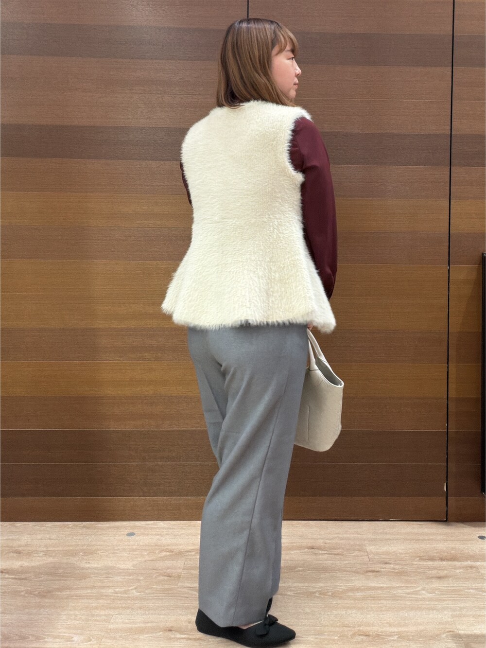 ベージュ系のベスト、レッド系のシャツ/ブラウス、グレー系のその他パンツを着用したレディースの秋コーディネートの6枚目の写真