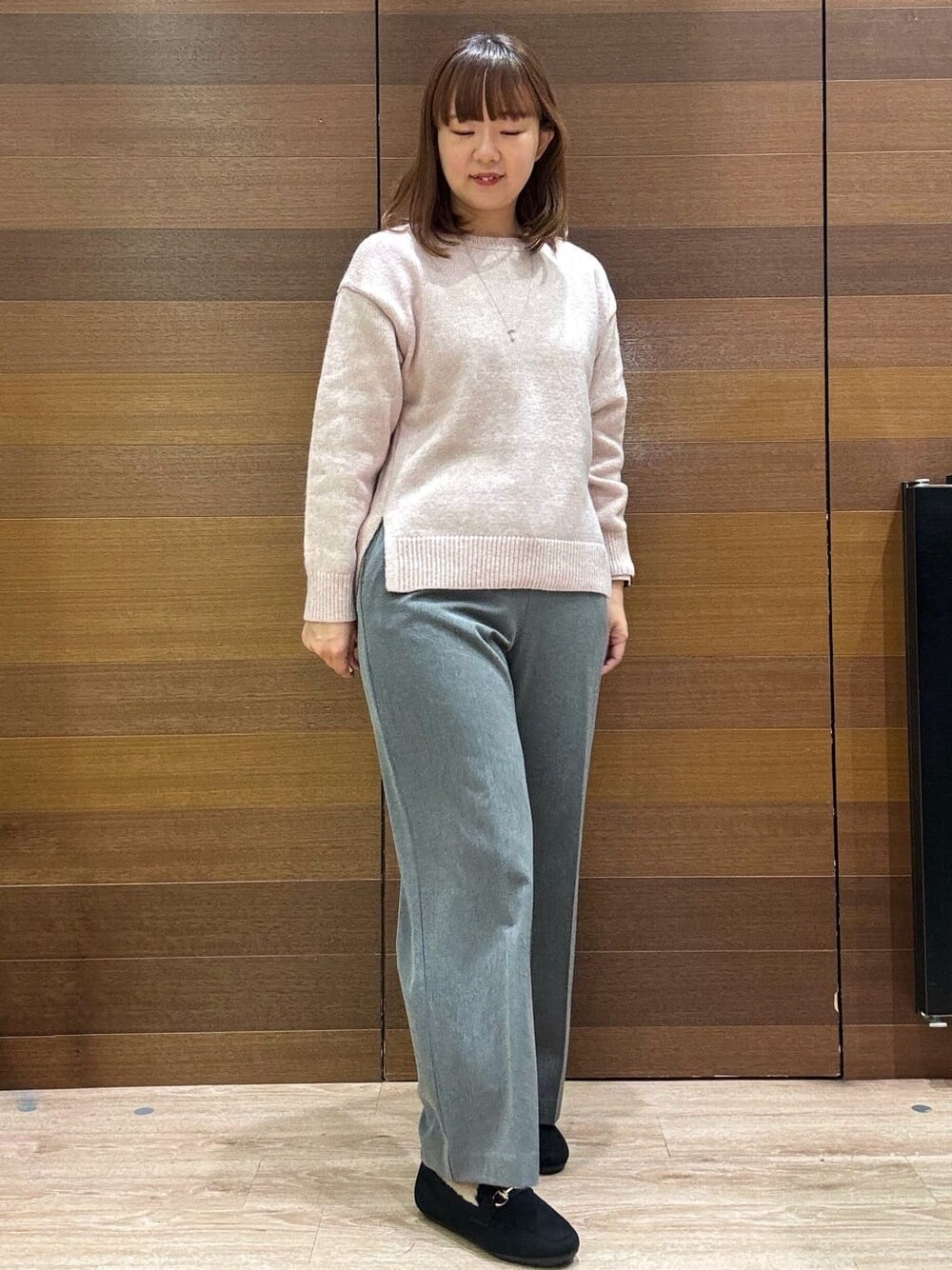 ピンク系のニット/セーター、グレー系のその他パンツ、ブラック系のパンプスを着用したレディースの冬コーディネートの6枚目の写真