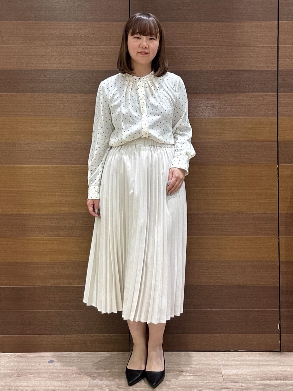 ホワイト系のノーカラージャケット、ベージュ系のシャツ/ブラウス、ベージュ系のスカートを着用したレディースの冬コーディネートの6枚目の写真
