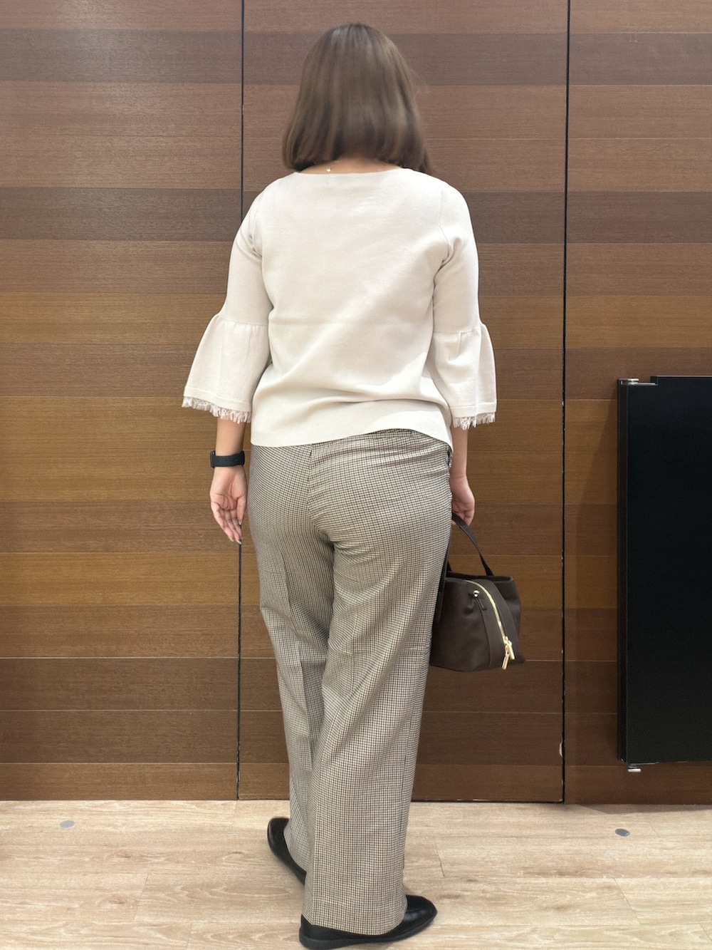 ベージュ系のニット/セーター、ブラウン系のその他パンツ、ブラウン系のボストンバッグを着用したレディースの秋コーディネートの6枚目の写真