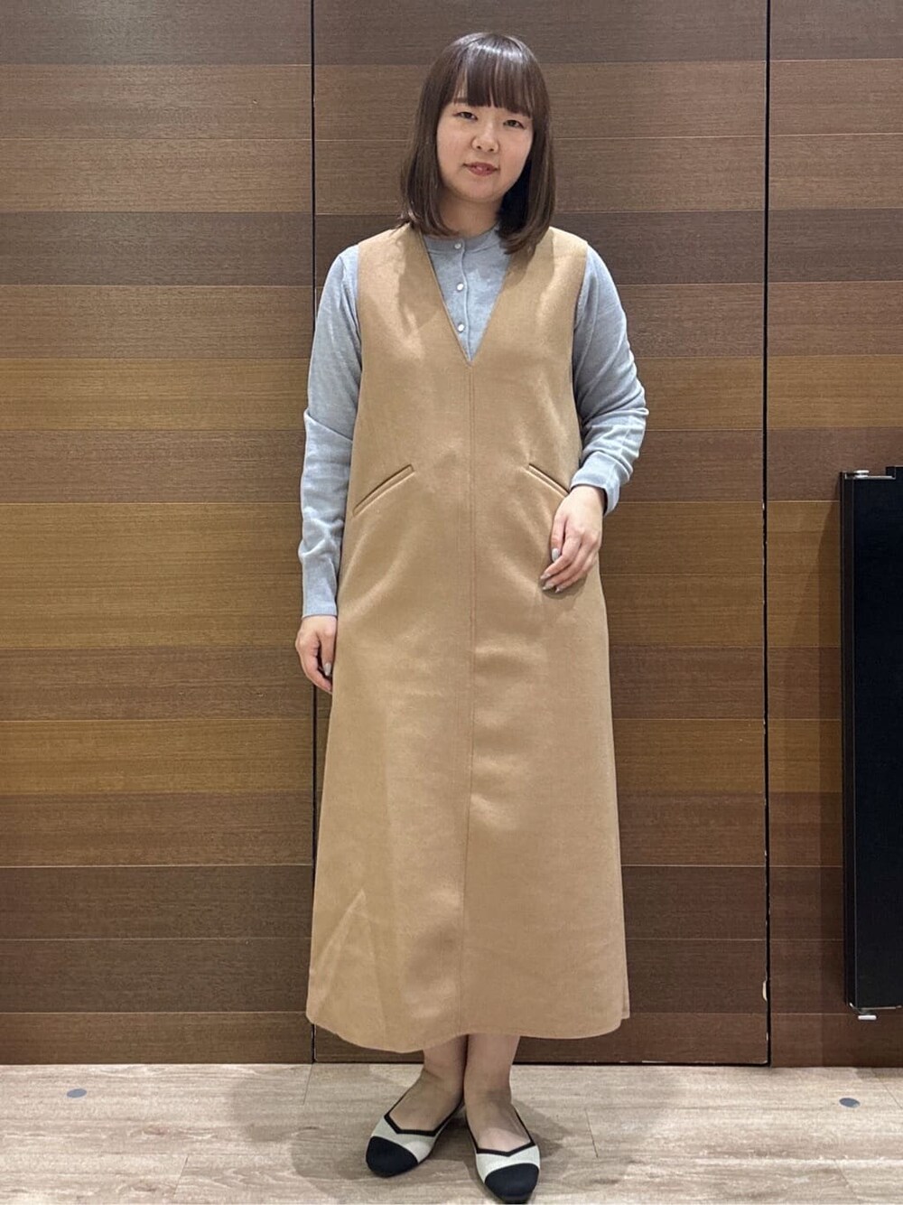 グレー系のカーディガン/ボレロ、イエロー系のワンピース、ベージュ系のトートバッグを着用したレディースの冬コーディネートの2枚目の写真