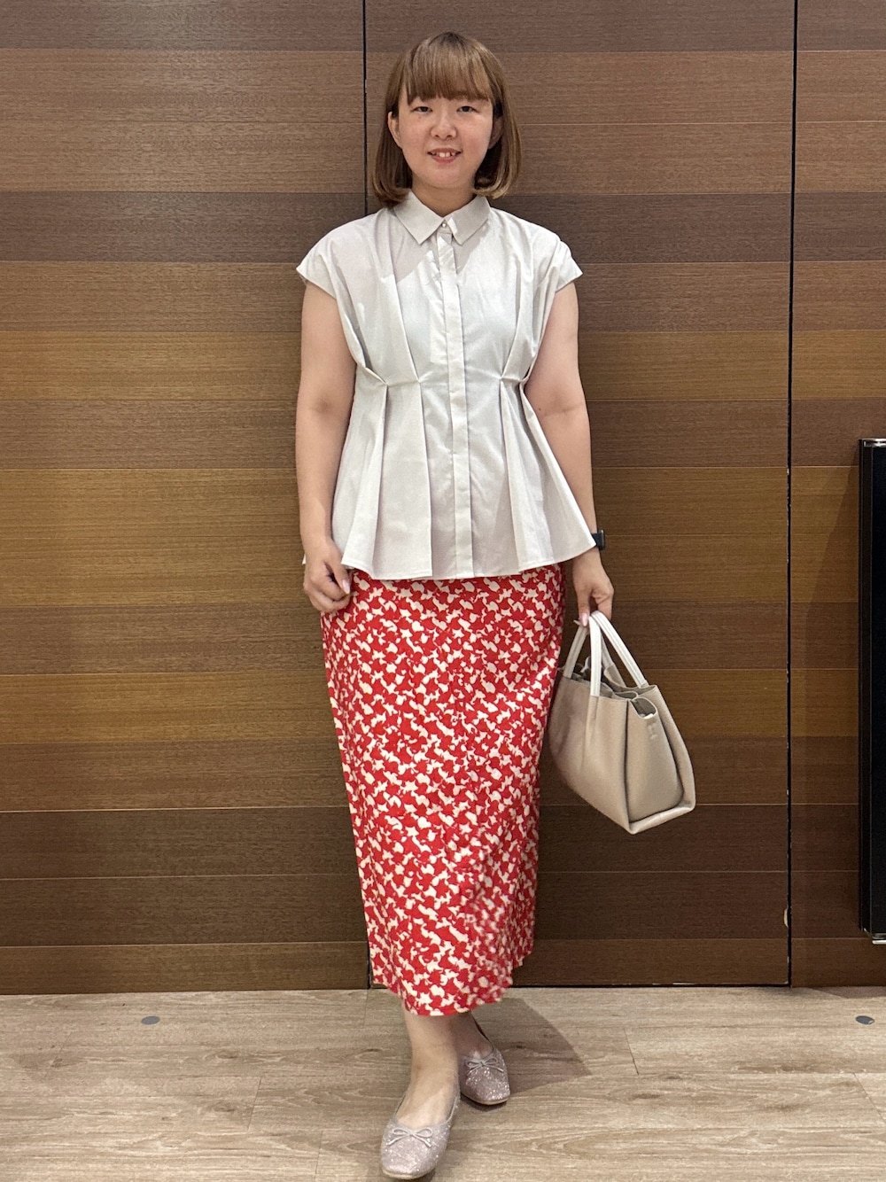 ベージュ系のシャツ/ブラウス、レッド系のスカート、ベージュ系のトートバッグを着用したレディースの夏コーディネートの2枚目の写真