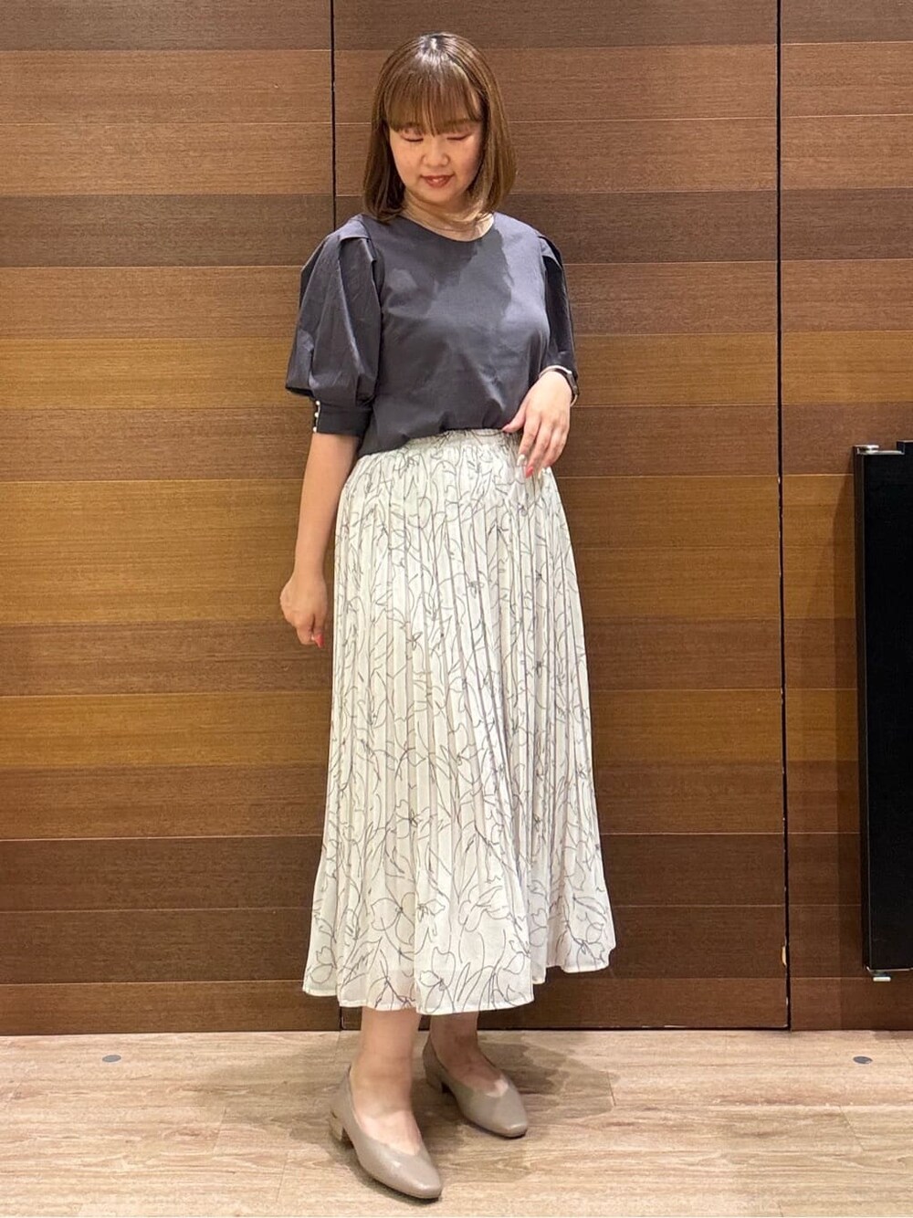 グレー系のTシャツ/カットソー、ブラック系のトートバッグ、ベージュ系のパンプスを着用したレディースの夏コーディネートの4枚目の写真