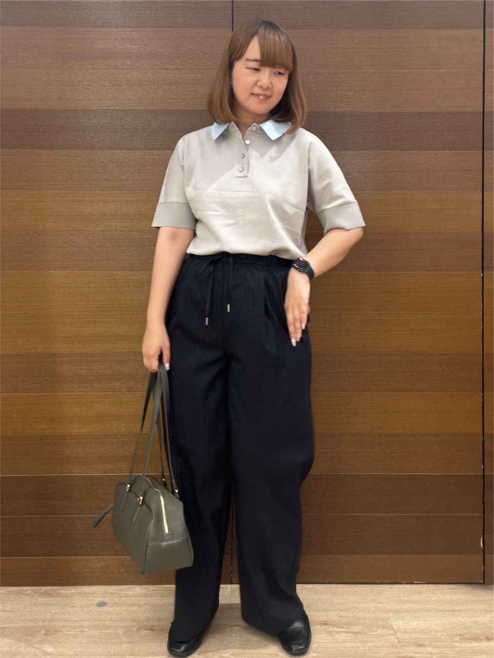 グレー系のニット/セーター、ブルー系のその他パンツ、グリーン系のボストンバッグを着用したレディースの秋コーディネートの3枚目の写真