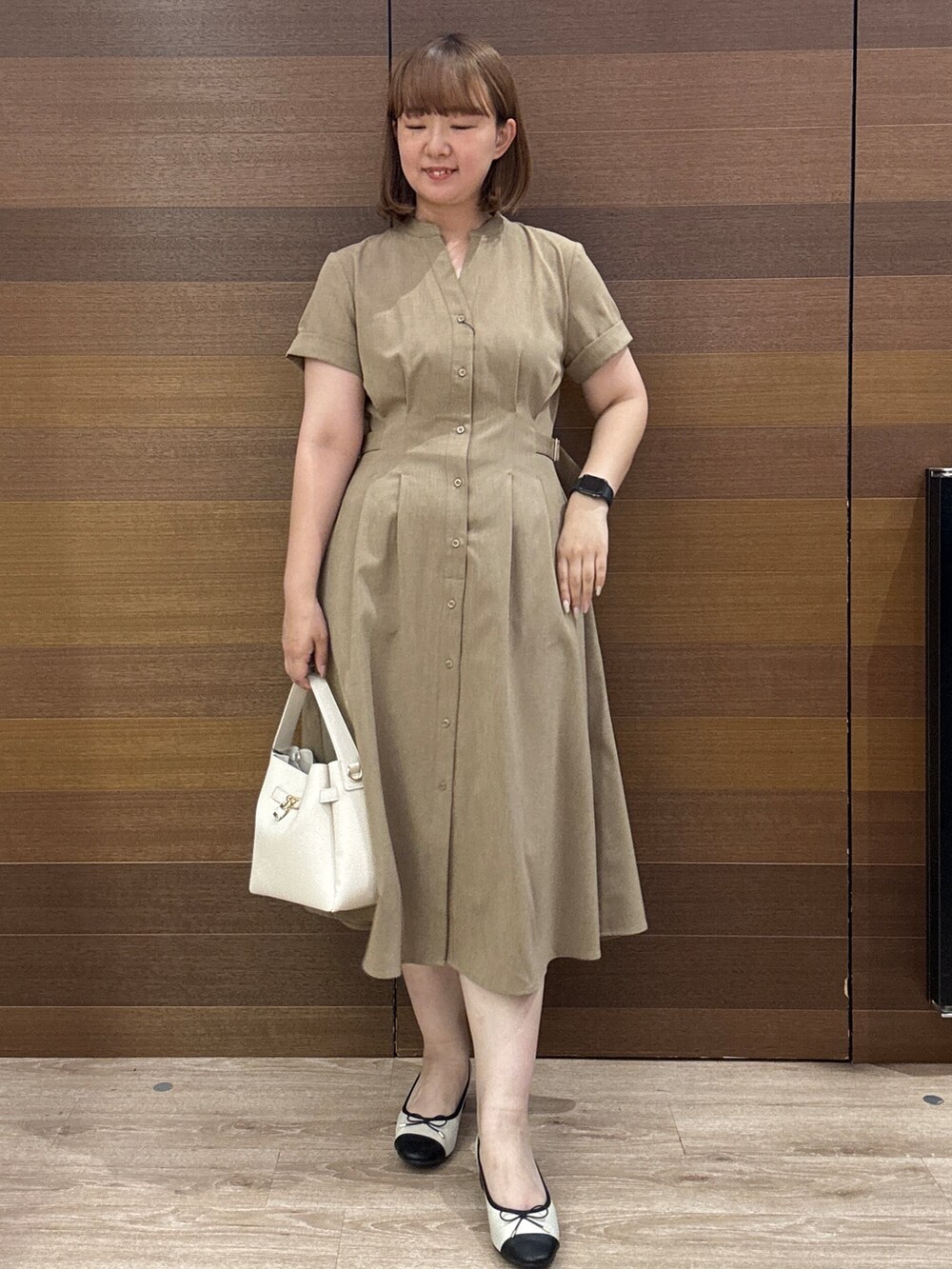 イエロー系のワンピース、ホワイト系のトートバッグ、ベージュ系のパンプスを着用したレディースの夏コーディネートの4枚目の写真