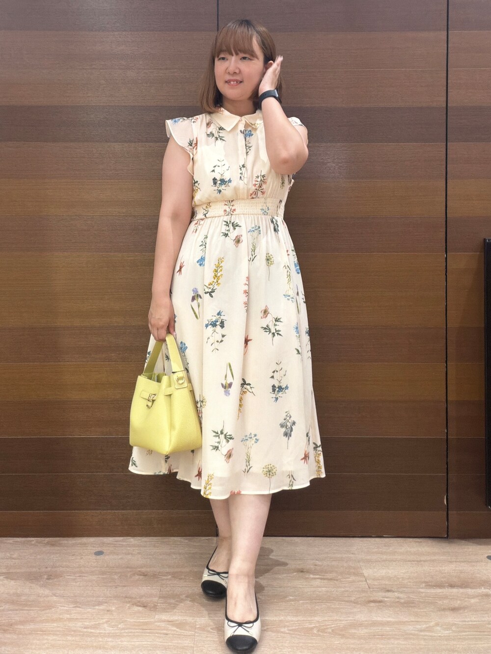 ベージュ系のワンピース、イエロー系のトートバッグ、ベージュ系のパンプスを着用したレディースの秋コーディネートの2枚目の写真