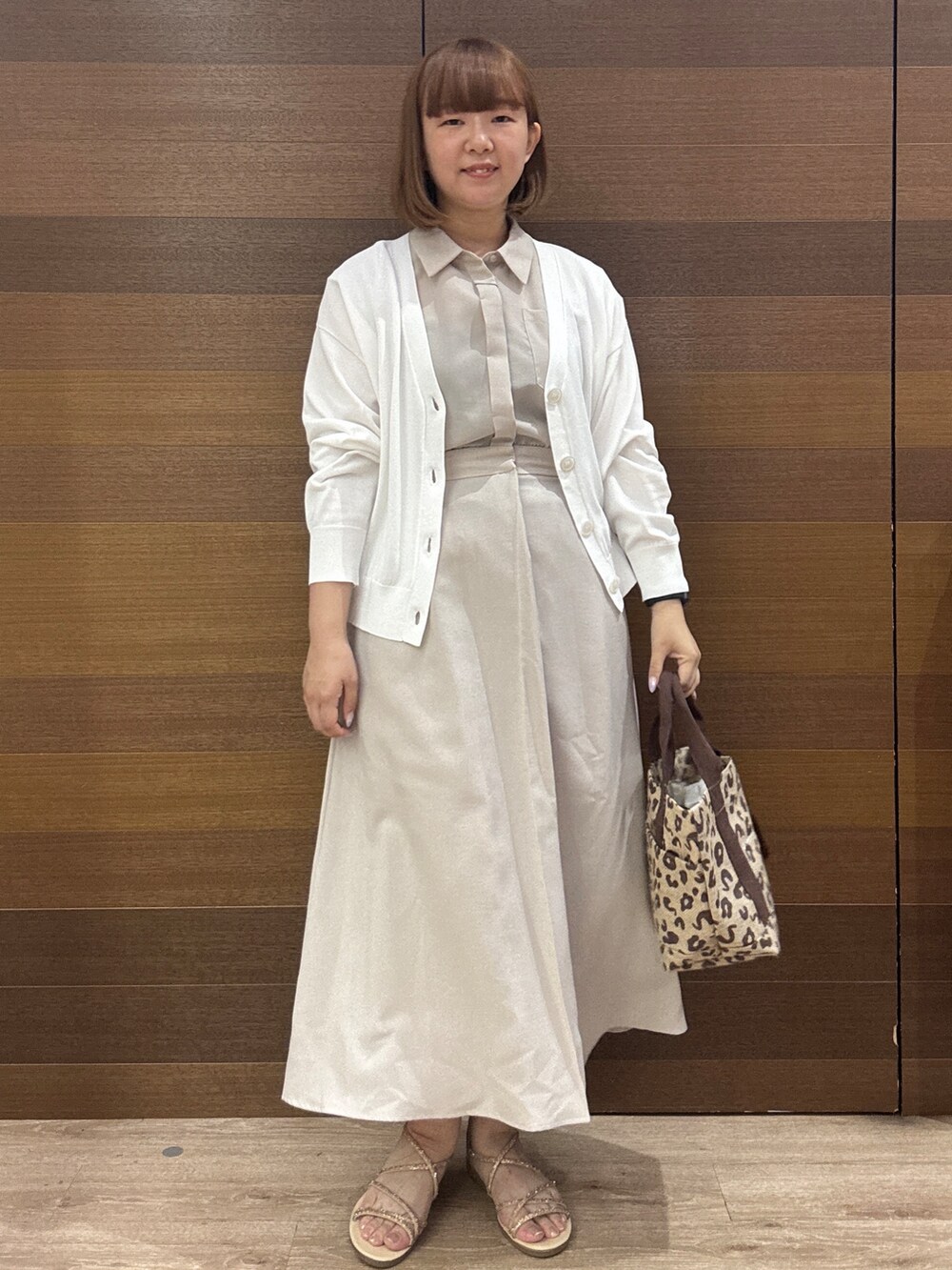 ベージュ系のワンピース、ブラウン系のトートバッグ、ゴールド系のサンダルを着用したレディースの夏コーディネートの3枚目の写真