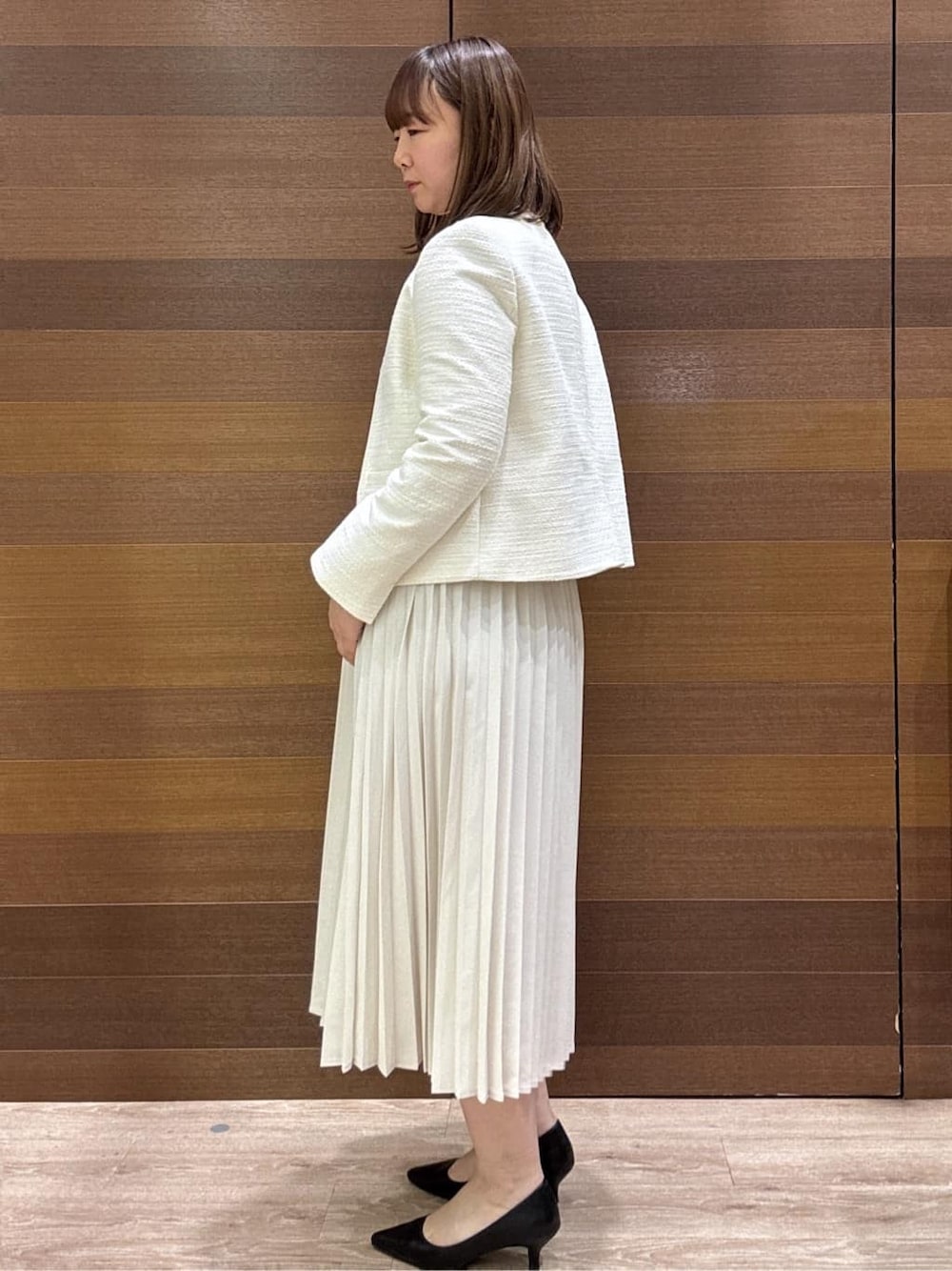 ホワイト系のノーカラージャケット、ベージュ系のシャツ/ブラウス、ベージュ系のスカートを着用したレディースの冬コーディネートの4枚目の写真