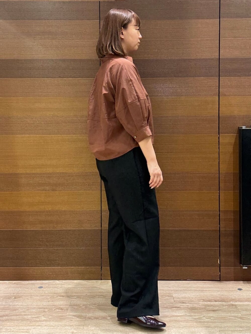 ブラウン系のシャツ/ブラウス、ブラック系のその他パンツ、ホワイト系のトートバッグを着用したレディースの秋コーディネートの3枚目の写真