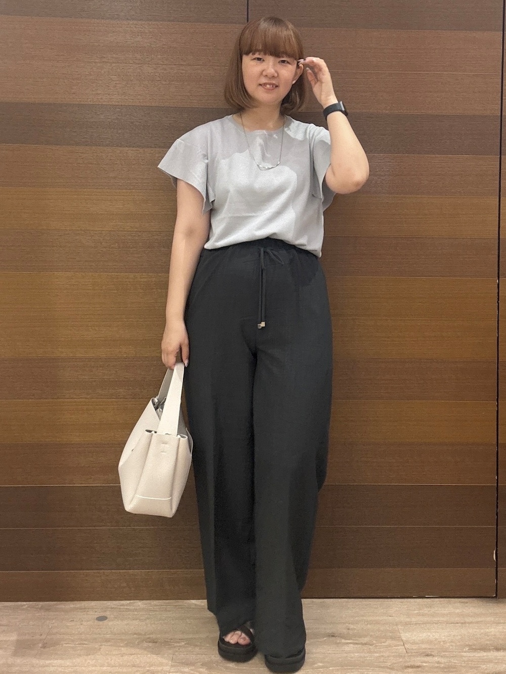 グレー系のニット/セーター、グレー系のその他パンツ、グレー系のトートバッグを着用したレディースの夏コーディネートの2枚目の写真