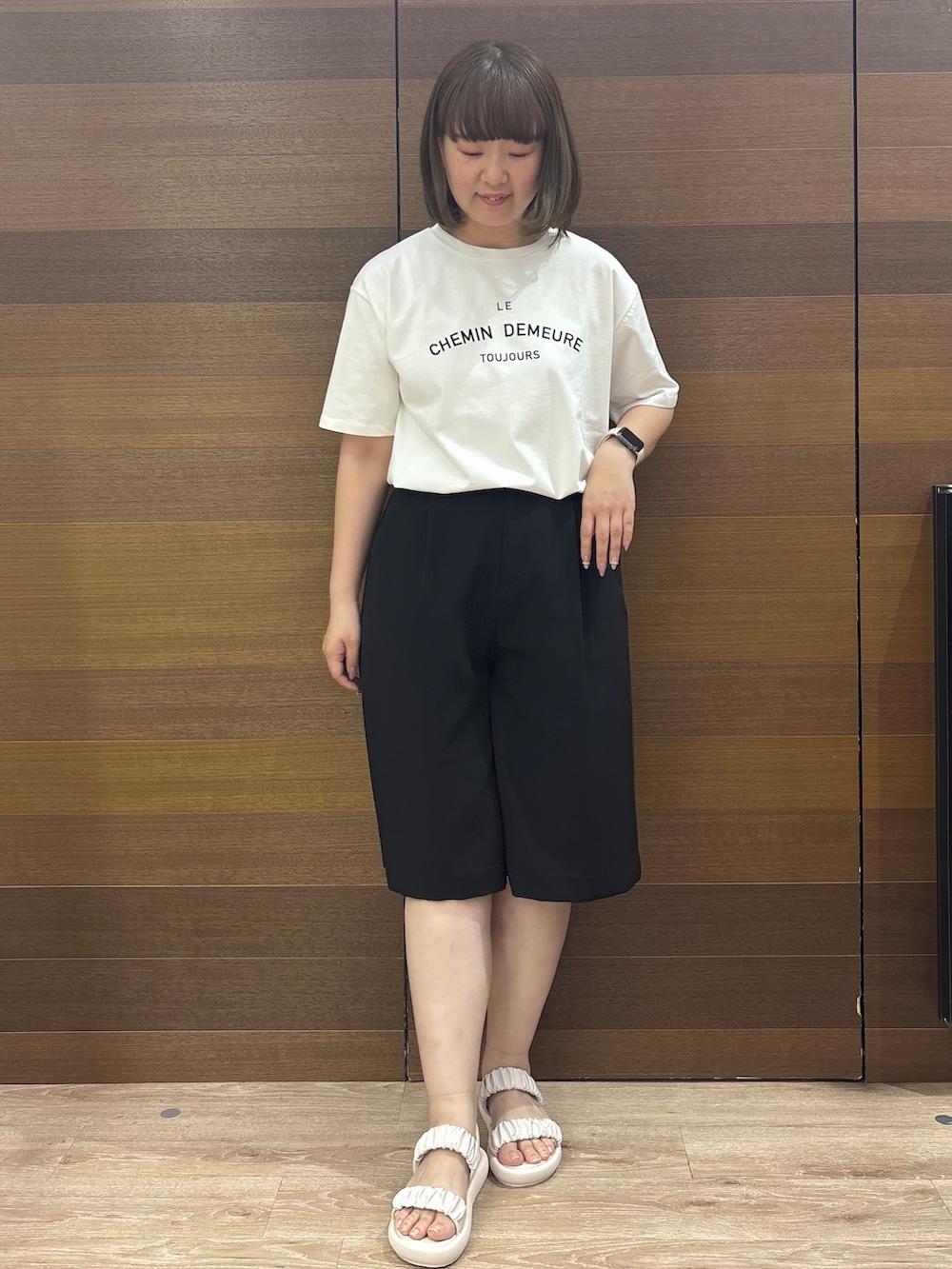 ホワイト系のトートバッグ、ホワイト系のサンダル、ブラック系のその他パンツを着用したレディースの春コーディネートの4枚目の写真