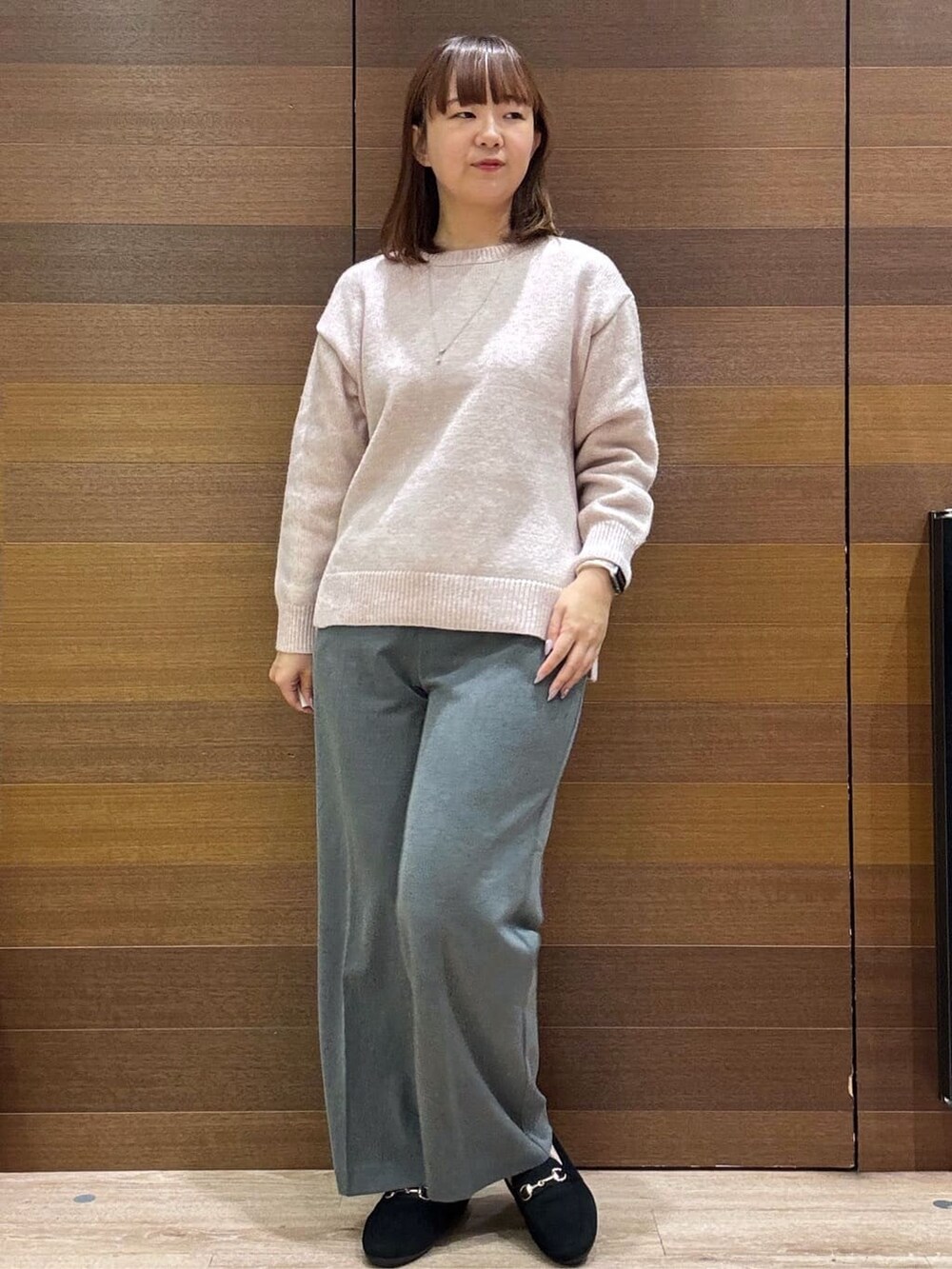 ピンク系のニット/セーター、グレー系のその他パンツ、ブラック系のパンプスを着用したレディースの冬コーディネートの2枚目の写真