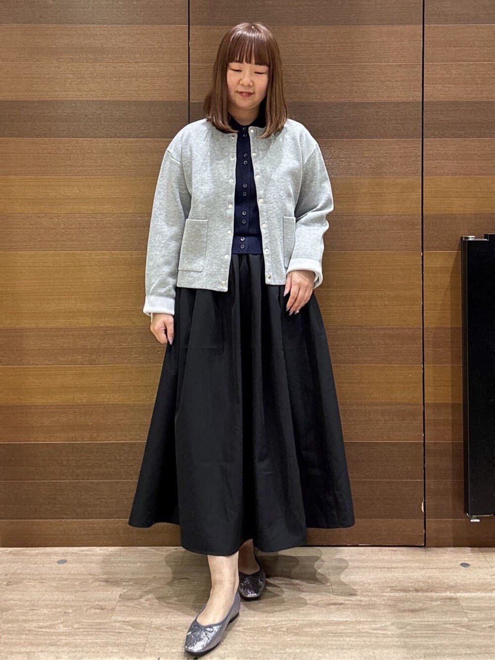 グレー系のカーディガン/ボレロ、ブルー系のワンピース、ブラック系のショルダーバッグを着用したレディースの冬コーディネートの2枚目の写真
