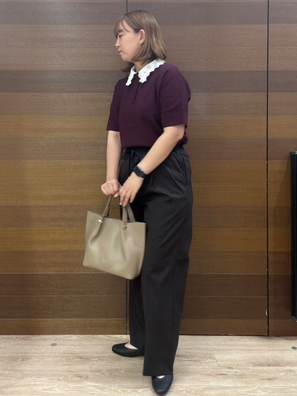 レッド系のニット/セーター、ブラウン系のその他パンツ、ベージュ系のショルダーバッグを着用したレディースの秋コーディネートの4枚目の写真