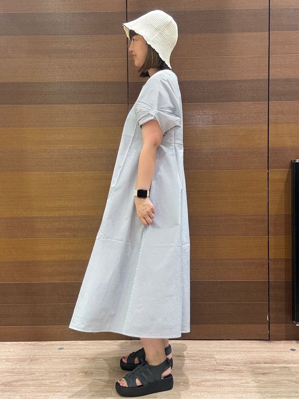 ホワイト系のワンピース、ブラック系のショルダーバッグ、グレー系のサンダルを着用したレディースの夏コーディネートの4枚目の写真