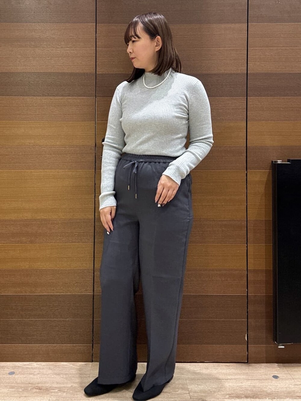 グレー系のニット/セーター、グレー系のその他パンツ、ブラック系のボストンバッグを着用したレディースの冬コーディネートの4枚目の写真