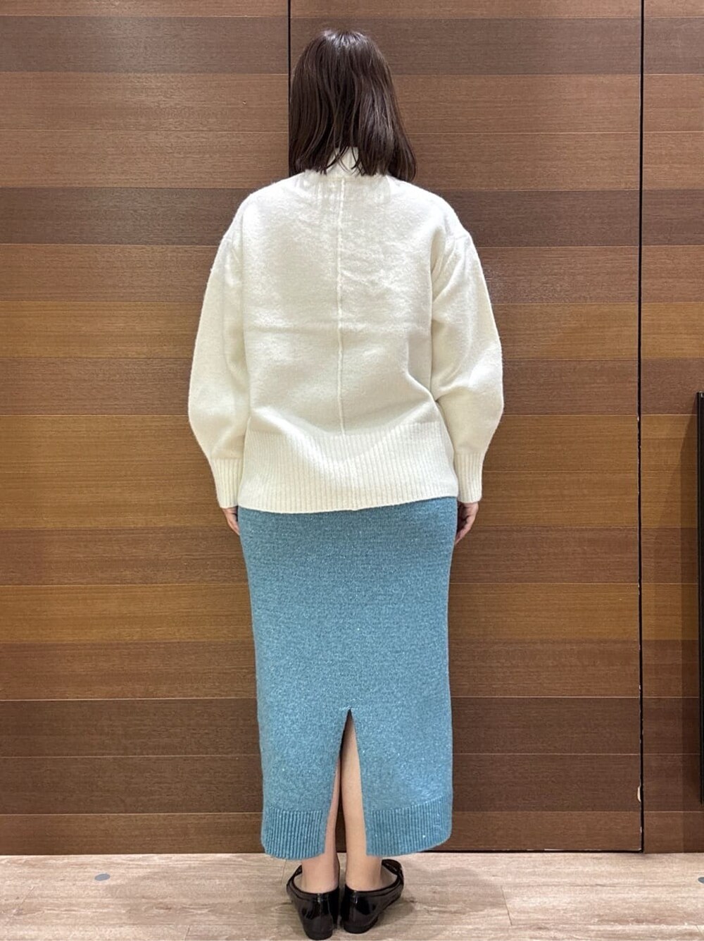 ホワイト系のニット/セーター、ブルー系のスカート、ブラック系のトートバッグを着用したレディースの冬コーディネートの9枚目の写真