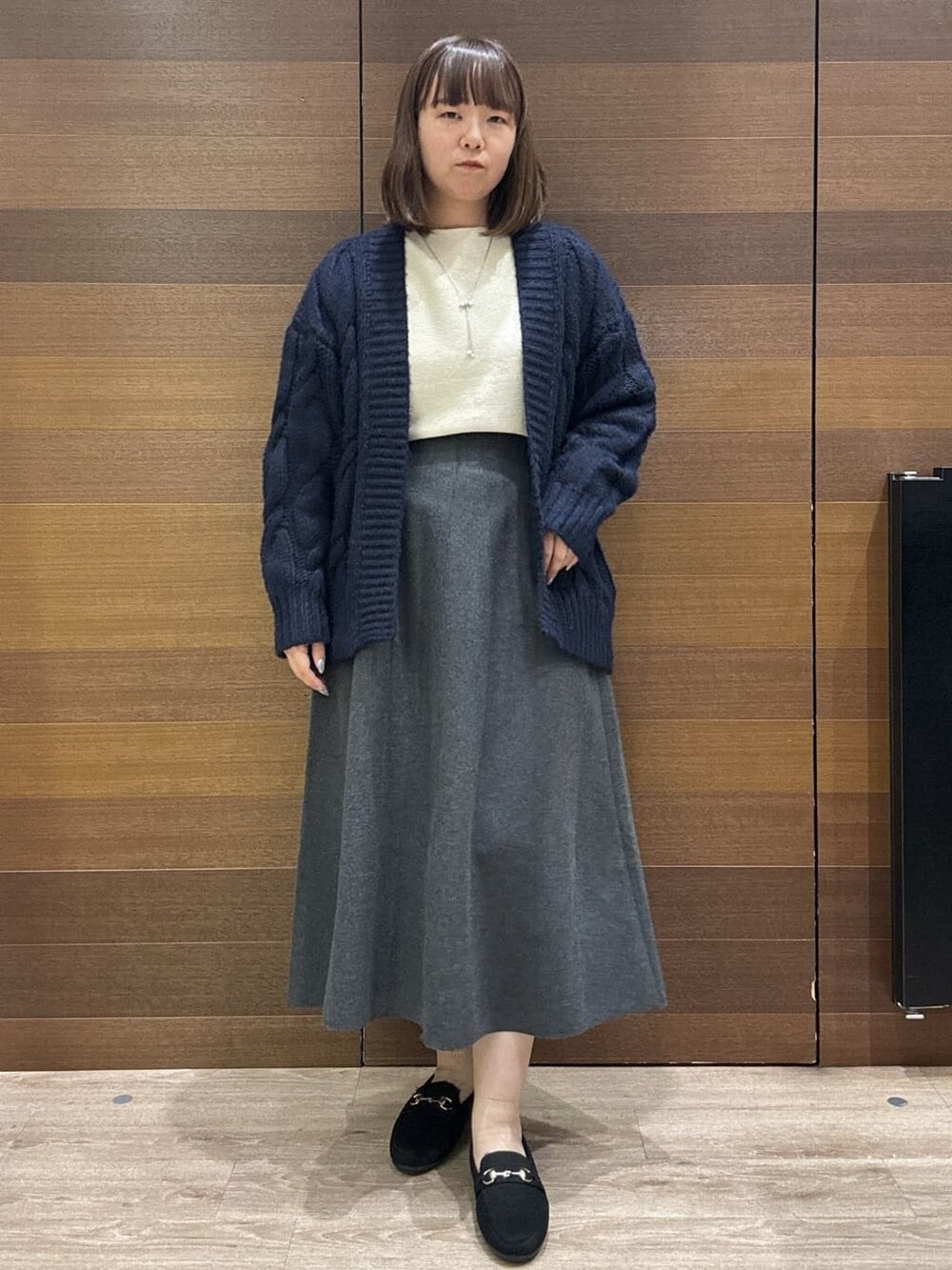 ブルー系のカーディガン/ボレロ、ホワイト系のニット/セーター、グレー系のスカートを着用したレディースの冬コーディネートの2枚目の写真