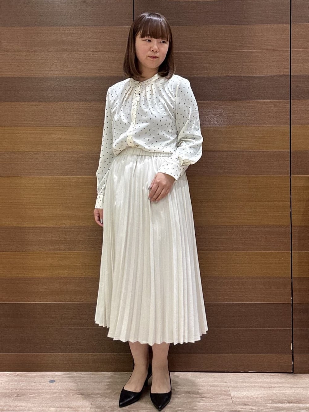 ホワイト系のノーカラージャケット、ベージュ系のシャツ/ブラウス、ベージュ系のスカートを着用したレディースの冬コーディネートの8枚目の写真