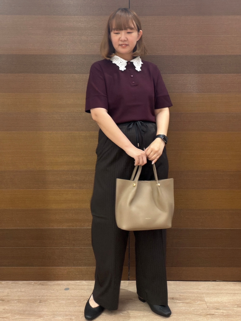 レッド系のニット/セーター、ブラウン系のその他パンツ、ベージュ系のショルダーバッグを着用したレディースの秋コーディネートの2枚目の写真