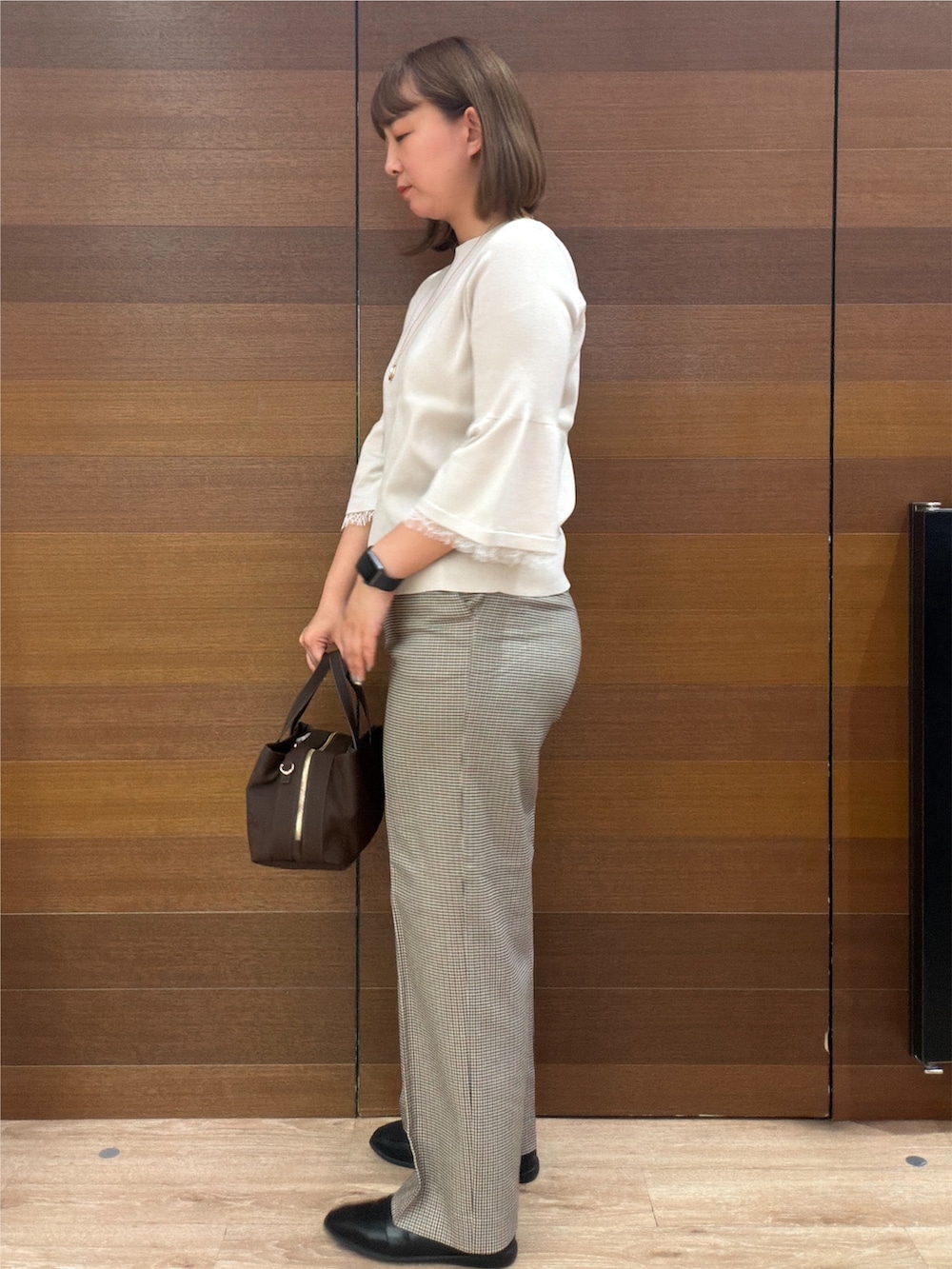 ベージュ系のニット/セーター、ブラウン系のその他パンツ、ブラウン系のボストンバッグを着用したレディースの秋コーディネートの8枚目の写真
