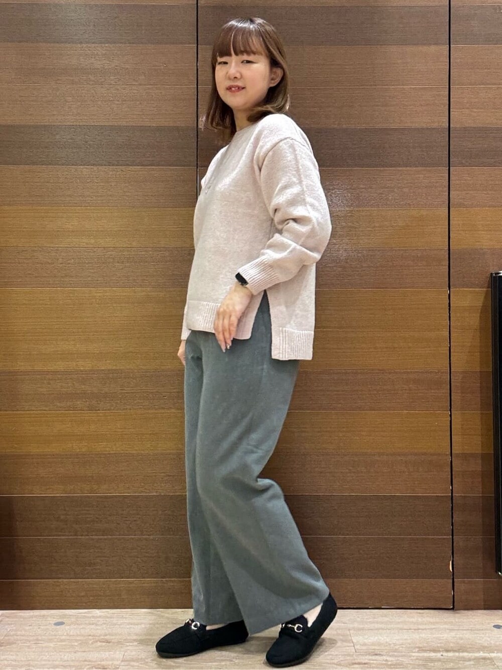ピンク系のニット/セーター、グレー系のその他パンツ、ブラック系のパンプスを着用したレディースの冬コーディネートの4枚目の写真