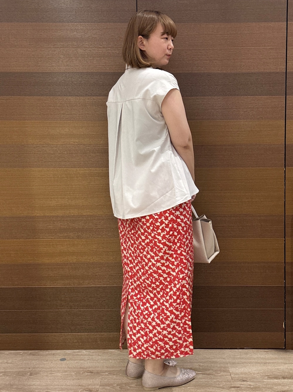ベージュ系のシャツ/ブラウス、レッド系のスカート、ベージュ系のトートバッグを着用したレディースの夏コーディネートの6枚目の写真
