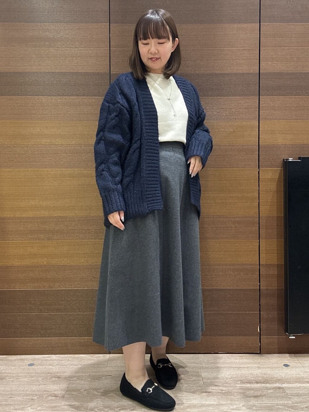 ブルー系のカーディガン/ボレロ、ホワイト系のニット/セーター、グレー系のスカートを着用したレディースの冬コーディネートの6枚目の写真