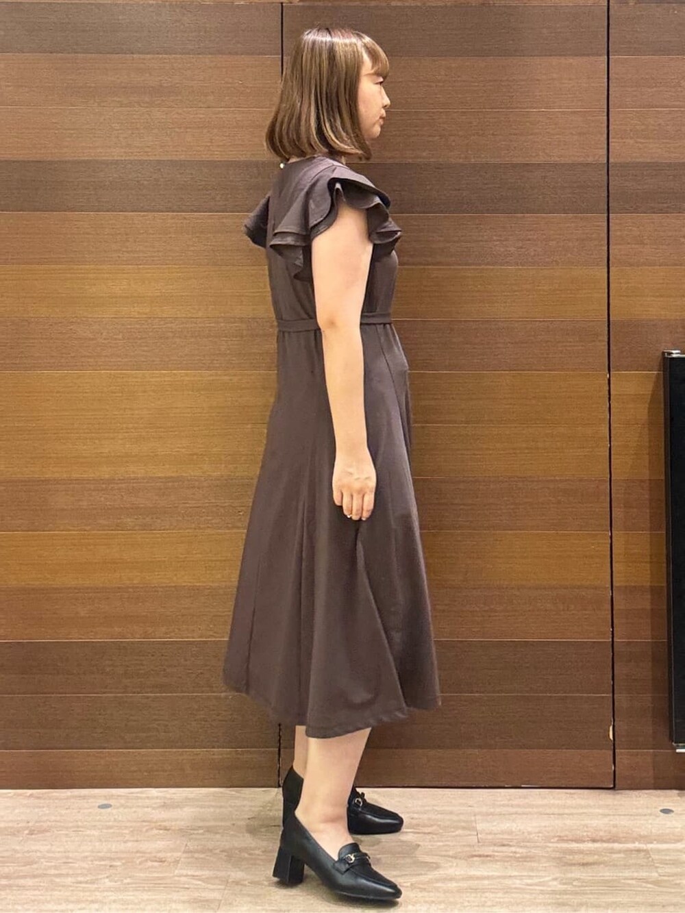 ブラウン系のワンピース、ベージュ系のトートバッグ、ブラック系のパンプスを着用したレディースの夏コーディネートの4枚目の写真