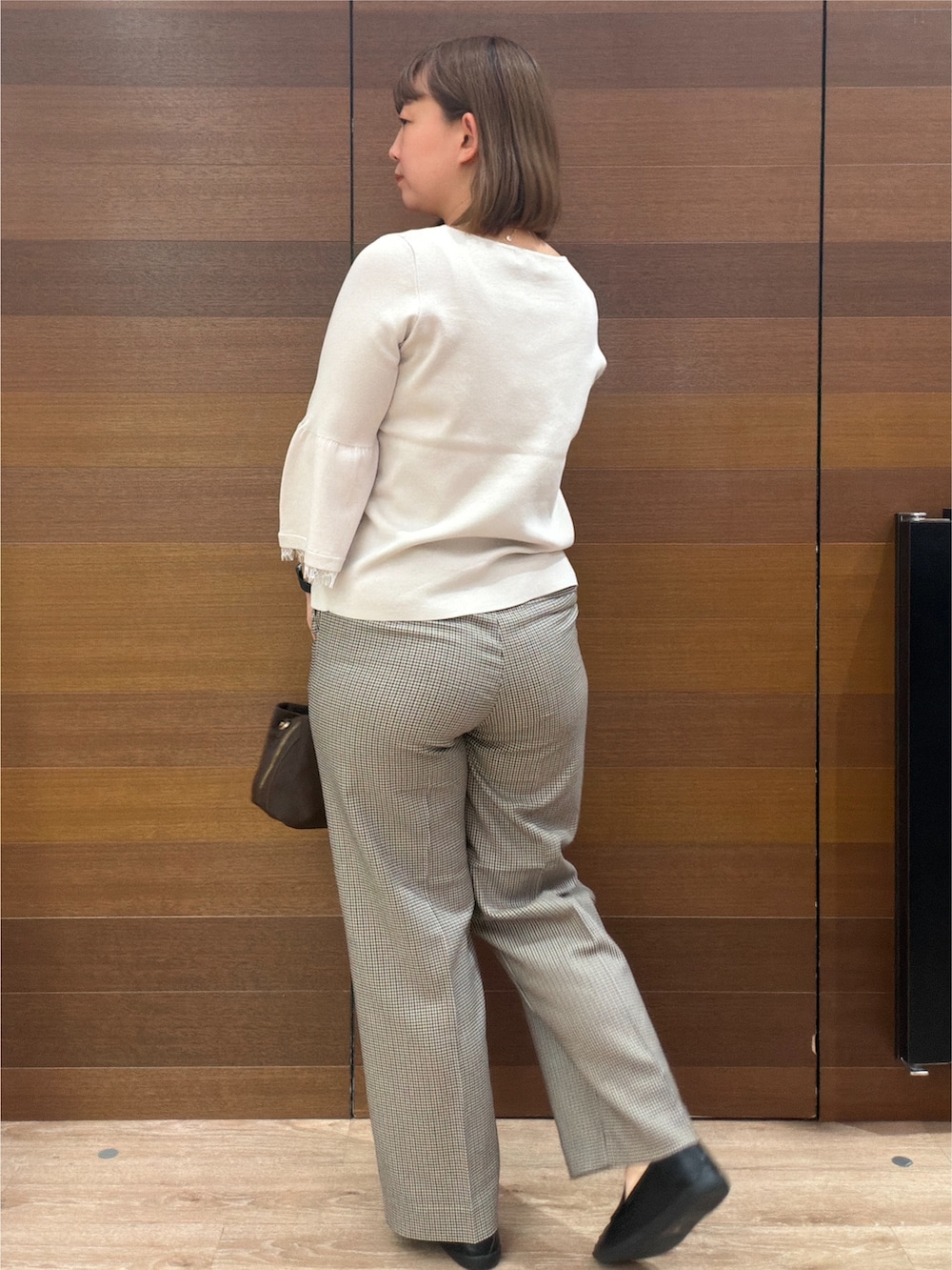 ベージュ系のニット/セーター、ブラウン系のその他パンツ、ブラウン系のボストンバッグを着用したレディースの秋コーディネートの5枚目の写真