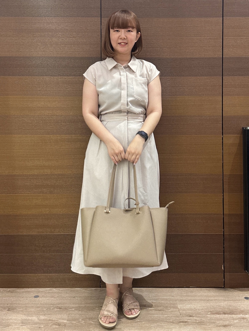 ベージュ系のワンピース、グレー系のトートバッグ、ゴールド系のサンダルを着用したレディースの夏コーディネートの3枚目の写真