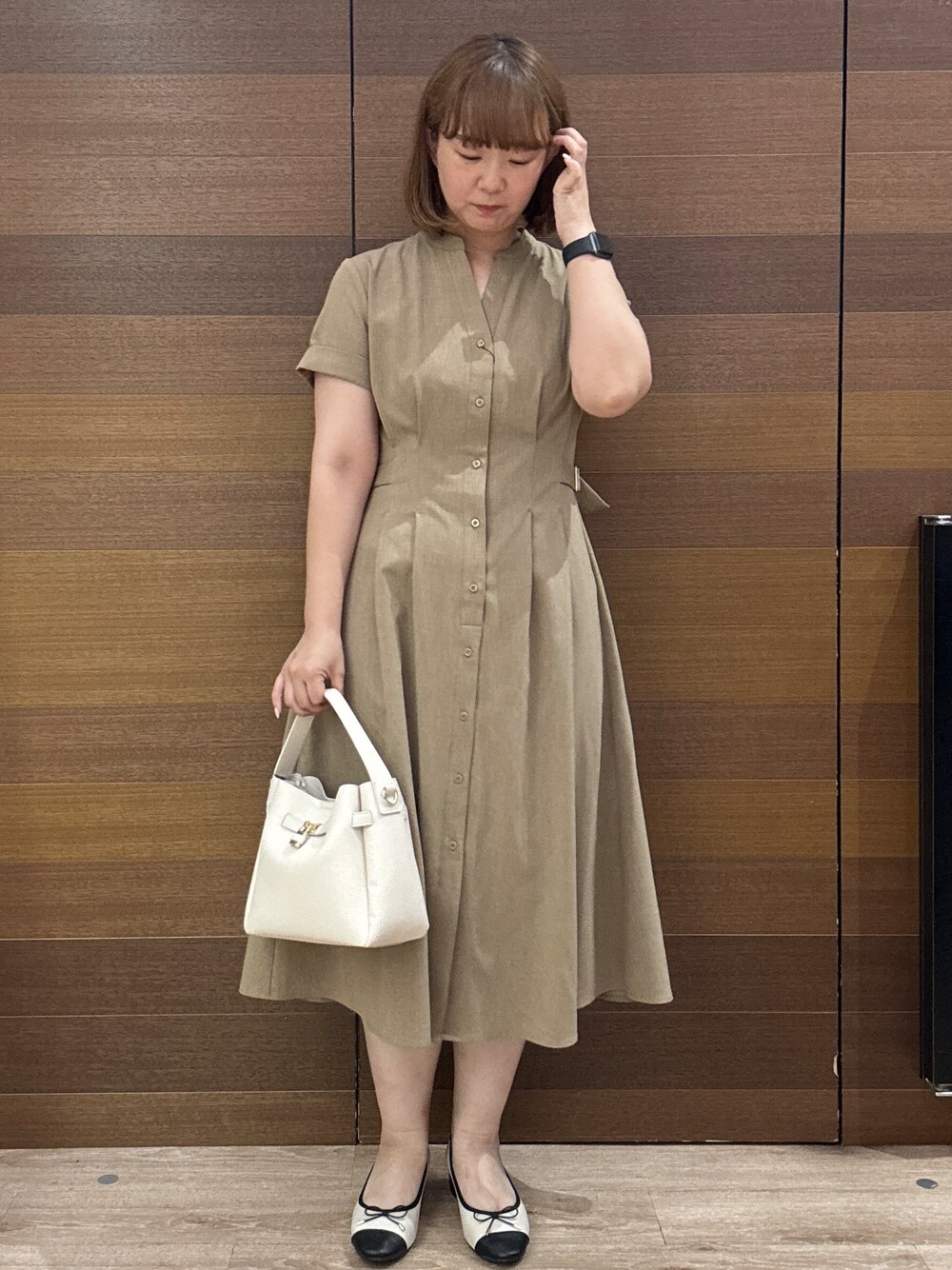 イエロー系のワンピース、ホワイト系のトートバッグ、ベージュ系のパンプスを着用したレディースの夏コーディネートの2枚目の写真