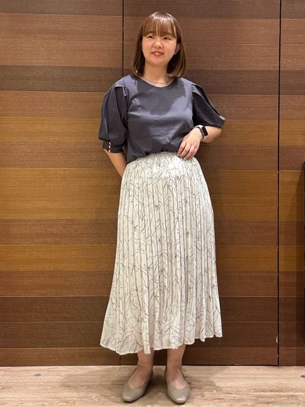 グレー系のTシャツ/カットソー、ブラック系のトートバッグ、ベージュ系のパンプスを着用したレディースの夏コーディネートの2枚目の写真