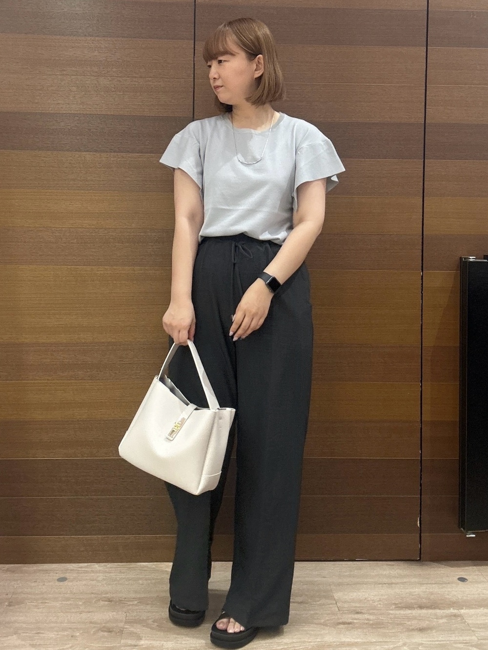 グレー系のニット/セーター、グレー系のその他パンツ、グレー系のトートバッグを着用したレディースの夏コーディネートの3枚目の写真