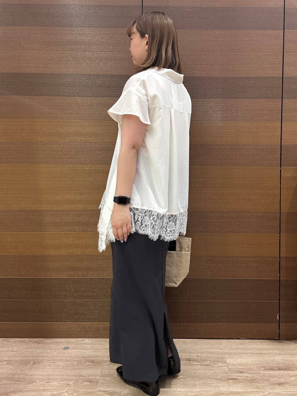 ホワイト系のシャツ/ブラウス、グレー系のスカート、ブラック系のトートバッグを着用したレディースの夏コーディネートの6枚目の写真